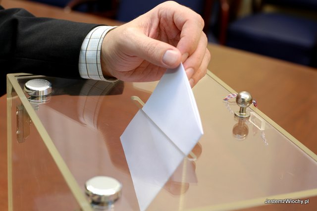 Dłoń wrzucająca kartę do urny wyborczej.